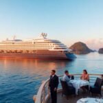 Luxury cruise ship in tropical waters at sunset.