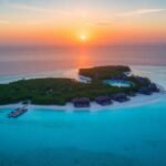 Vista aérea de um resort exclusivo na ilha ao pôr do sol.