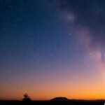 Star-filled night sky over a peaceful cabin retreat.