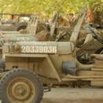 Several vintage army jeeps are lined up.