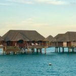 a row of huts sitting on top of a body of water