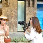 a woman filming another woman with a camera