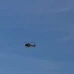 black helicopter flying in the sky during daytime