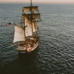 brown sailboat in beach under white sky