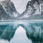 body of water and snow-covered mountains during daytime