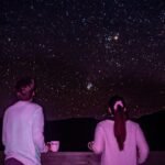 man and woman standing in front of galaxy