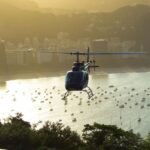 gray helicopter flying near buildings during daytime